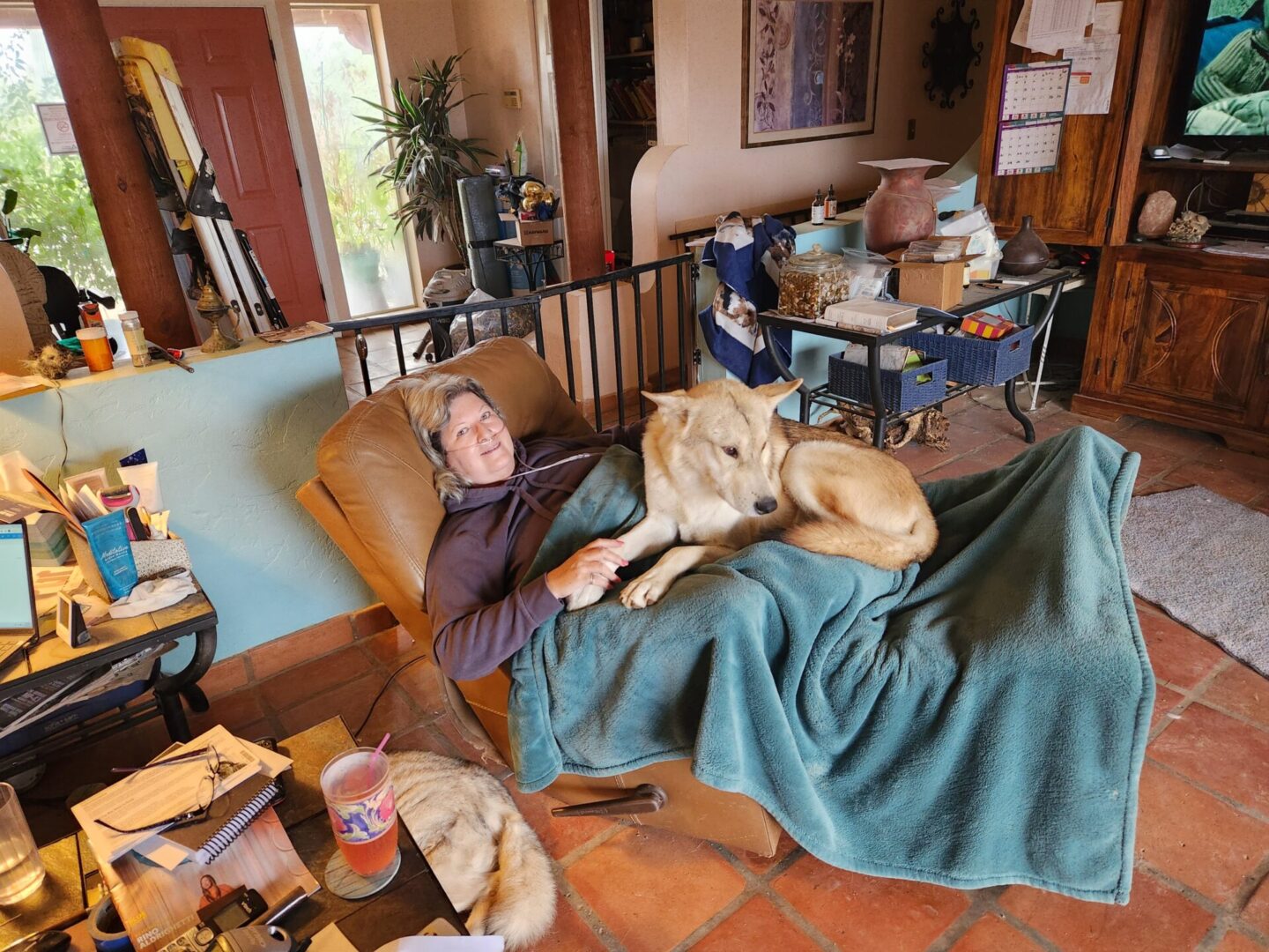 A woman and her dog are laying on the bed.